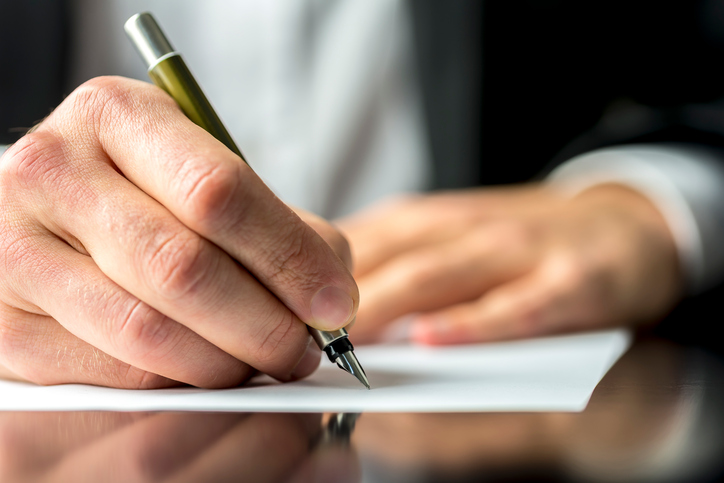 <span class="dojodigital_toggle_title">Businessman signing or writing a document</span>